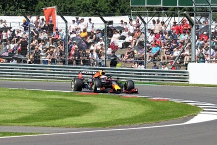 f1 racecar on turn at silvestone circuit in british grand prix