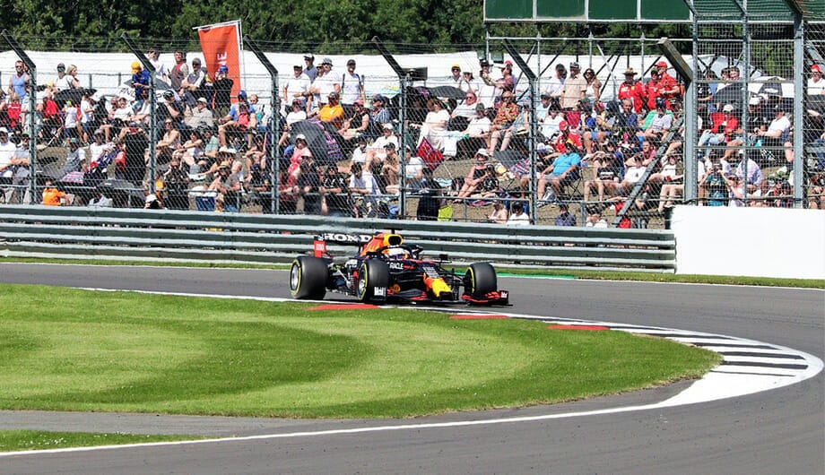 f1 racecar on turn at silvestone circuit in british grand prix