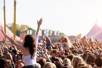 Girl dancing in crowd at popular music festival in Europe