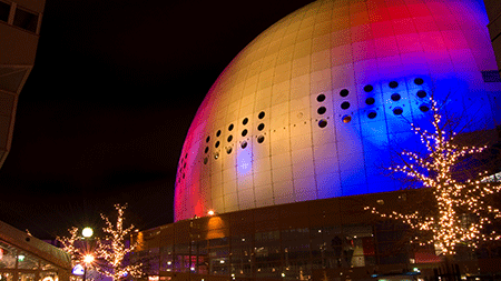 Popular Stockholm concert arena at night with red and blue lights on facade