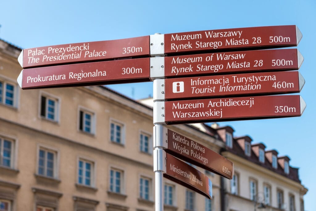 Warsaw, Poland Old town historic street city during sunny summer day Krakowskie Przedmiescie and direction information sign