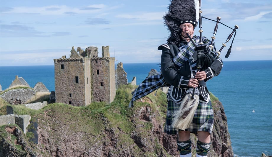 Bagpiper in front of one of Scotland's most popular castles to visit.