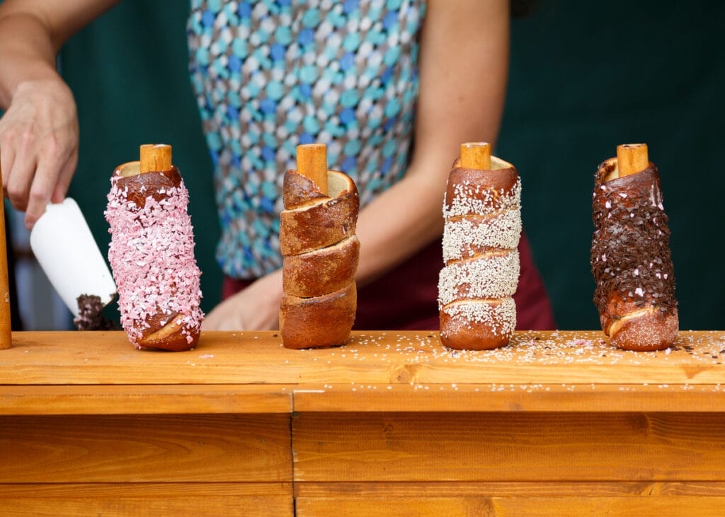 Trdelnik Czech traditional delicacy made from dough wrapped around a wooden or metal cylinder and roasted over an open fire for sale at Prague festival.